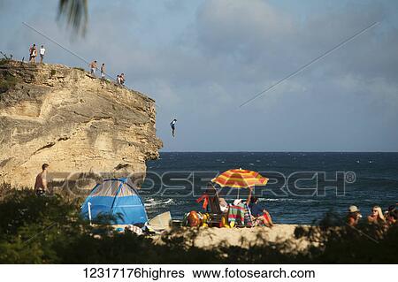 Cliff jumping and beach goers, Keoniloa Beach and Bay, also k0wn as Ship Wreck Beach; Poipu, Kauai, Hawaii, United States of America View Large Photo Image Stock Photograph - Cliff jumping and beach goers, Keoniloa Beach and Bay, also k0wn as Ship Wreck Beach; Poipu, Kauai, Hawaii, United States of America. Fotosearch