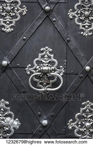Stock Photograph - Close-up detail of the architectural detail of a door with silver knocker; Prague, Czech Republic. Fotosearch
