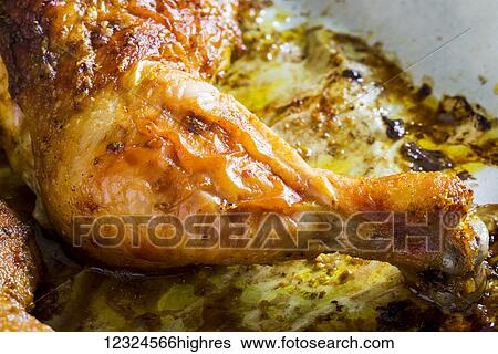 Stock Photograph - Close-up of a crispy baked chicken leg; Calgary, Alberta, Canada. Fotosearch