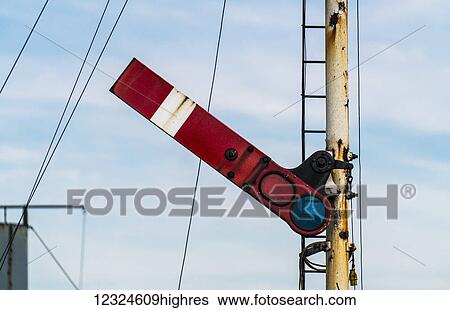 Stock Photograph - Close-up of a railroad barrier at a crossing against a cloudy sky; Yorkshire, England. Fotosearch