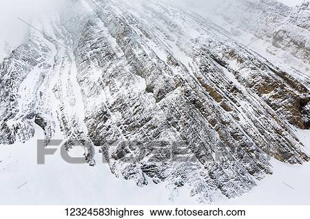 Close up of a snow covered mountain face with line pattern from rock formation; Kananaskis Country, Alberta, Canada View Large Photo Image Stock Photograph - Close up of a snow covered mountain face with line pattern from rock formation; Kananaskis Country, Alberta, Canada. Fotosearch