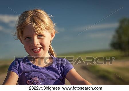 Close up portrait of a young girl with blond hair and a rural landscape in the background; Herschel, Saskatchewan, Canada View Large Photo Image Stock Photograph - Close up portrait of a young girl with blond hair and a rural landscape in the background; Herschel, Saskatchewan, Canada. Fotosearch
