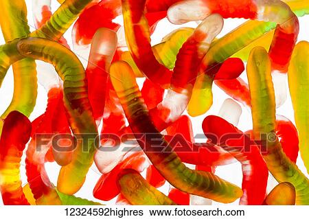 Stock Photograph - Colourful candied gummy worms backlit; Calgary, Alberta, Canada. Fotosearch