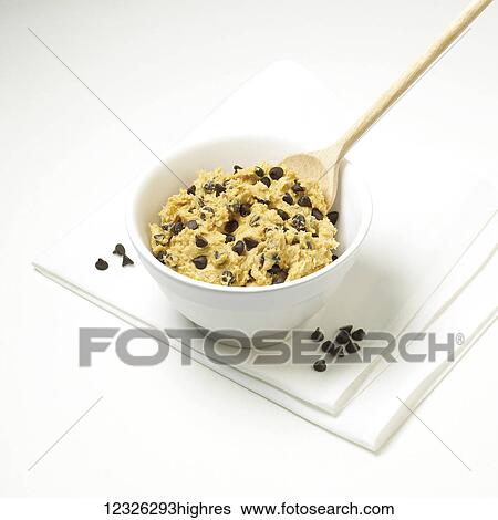 Cookie dough with chocolate chips in a bowl with a wooden spoon on a white background View Large Photo Image Stock Photograph - Cookie dough with chocolate chips in a bowl with a wooden spoon on a white background. Fotosearch