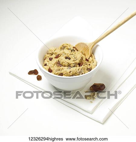 Cookie dough with raisins in a bowl with a wooden spoon on a white background View Large Photo Image Stock Photograph - Cookie dough with raisins in a bowl with a wooden spoon on a white background. Fotosearch