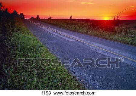 Stock Image - Country road at sunset. Fotosearch