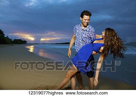 Stock Photograph - Couple on a beach; Kealia, Kauai, Hawaii, United States of America. Fotosearch