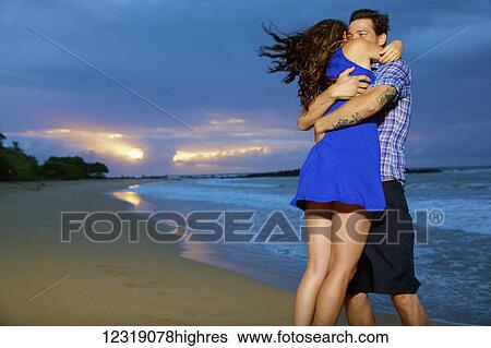 Stock Photograph - Couple on a beach; Kealia, Kauai, Hawaii, United States of America. Fotosearch