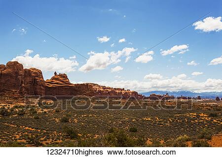 Desert landscape of rugged rock formations under a blue sky with cloud, Arches National Park; Utah, United States of America View Large Photo Image Stock Photograph - Desert landscape of rugged rock formations under a blue sky with cloud, Arches National Park; Utah, United States of America. Fotosearch
