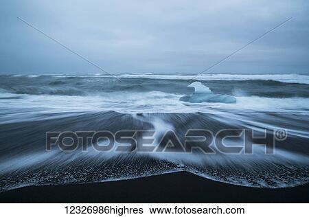 Diamond Beach, along the South coast and is an area where ice chunks from Jokulsarlon are deposited on the beach after each high tide; Iceland View Large Photo Image Stock Photograph - Diamond Beach, along the South coast and is an area where ice chunks from Jokulsarlon are deposited on the beach after each high tide; Iceland. Fotosearch