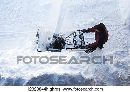 Directly above a man using a snowblower; Homer, Alaska, United States of America View Large Photo Image Stock Photograph - Directly above a man using a snowblower; Homer, Alaska, United States of America. Fotosearch