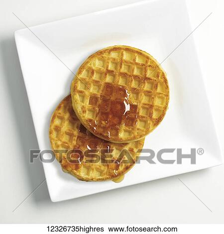 Directly above waffles with syrup on a white plate View Large Photo Image Stock Photograph - Directly above waffles with syrup on a white plate. Fotosearch