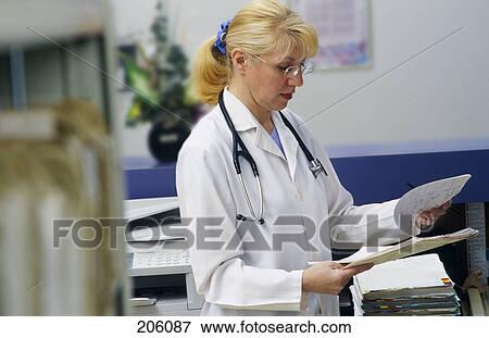 Stock Photo - Doctor or nurse reading patient record. Fotosearch