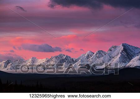 Dramatically glowing sky at sunrise with snow covered mountain range and fog in the valley; Kananaskis Country, Alberta, Canada View Large Photo Image Stock Photograph - Dramatically glowing sky at sunrise with snow covered mountain range and fog in the valley; Kananaskis Country, Alberta, Canada. Fotosearch