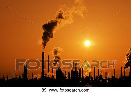 Stock Photo - Factory chimneys against an orange sunset. Fotosearch