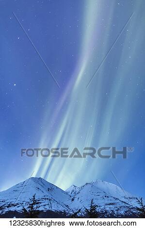 Stock Photograph - Faint green and purple Aurora Borealis dances over the Kenai Mountains, Moose Pass, Kenai Peninsula, South-central Alaska; Alaska, United States of America. Fotosearch