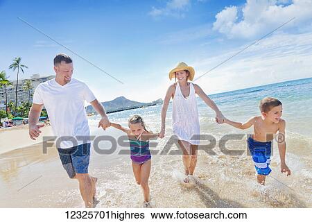 Family of four enjoying a summer vacation in Waikiki Beach; Honolulu, Oahu, Hawaii, United States of America View Large Photo Image Stock Photograph - Family of four enjoying a summer vacation in Waikiki Beach; Honolulu, Oahu, Hawaii, United States of America. Fotosearch