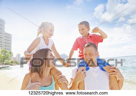 Stock Photograph - Family of four enjoying a summer vacation in Waikiki Beach; Honolulu, Oahu, Hawaii, United States of America. Fotosearch