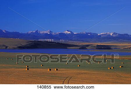 Stock Photography - Farmer's field with river and mountains in background. Fotosearch