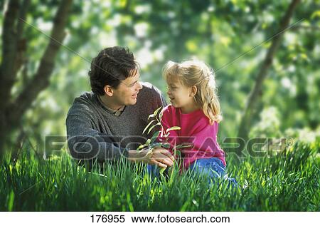 Father and daughter sitting on the grass View Large Photo Image Stock Photography - Father and daughter sitting on the grass. Fotosearch