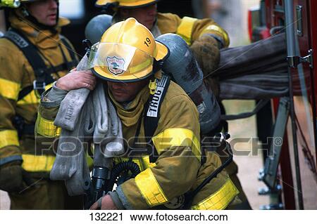 Stock Image - Fireman carrying hose. Fotosearch
