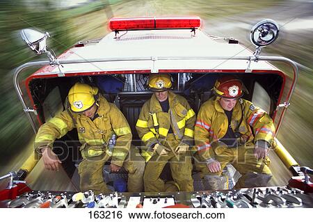 Firemen riding on back of fire truck View Large Photo Image Stock Photograph - Firemen riding on back of fire truck. Fotosearch