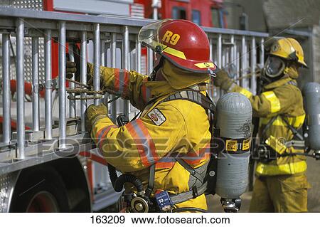 Stock Photo - Firemen tying ladder to fire truck. Fotosearch