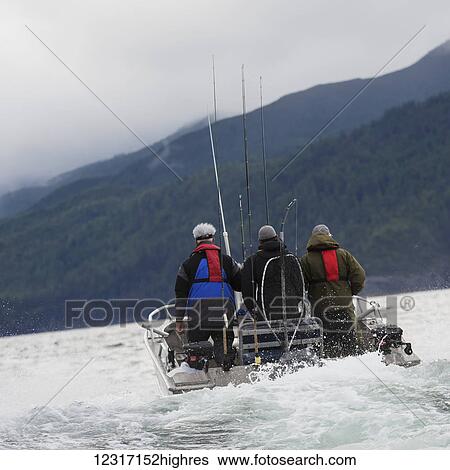 Stock Photograph - Fishermen heading out to fish in a boat off the Queen Charlotte Islands; British Columbia, Canada. Fotosearch