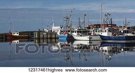 Stock Photograph - Fishing boats moored in the tranquil water of a harbour; Petit Etang, 0va Scotia, Canada. Fotosearch