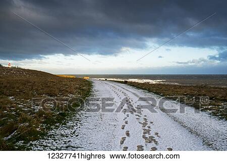 Stock Photograph - Footprints in the snow down a trail leading to the horizon; South Shields, Tyne and Wear, England. Fotosearch