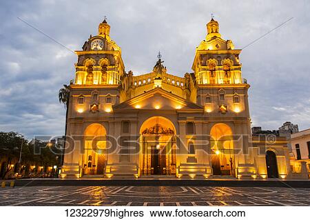 Stock Photograph - Fully lit South American church and plaza at dusk; Cordoba, Argentina. Fotosearch