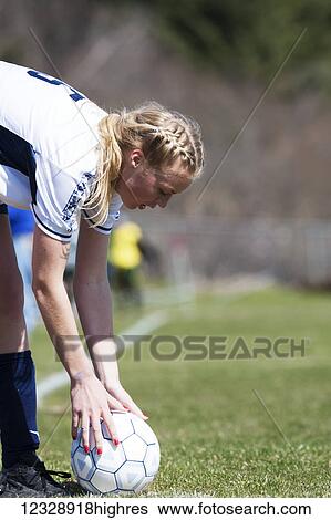 Stock Photograph - Girl reaching for soccer ball from the sidelines; Homer, Alaska, United States of America. Fotosearch