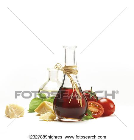 Stock Photograph - Glass jars of balsamic vinegar and olive oil with basil, tomato and parmesan cheese on a white background. Fotosearch