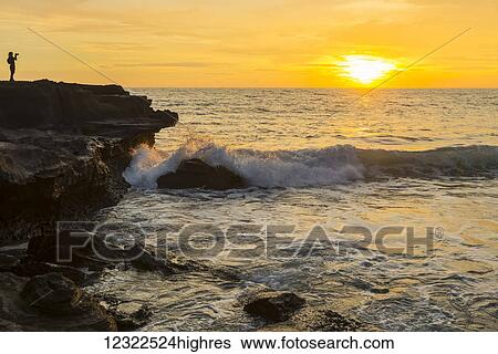 Golden sunset over the ocean with a view of the coastline; Bali Island, Indonesia View Large Photo Image Stock Photograph - Golden sunset over the ocean with a view of the coastline; Bali Island, Indonesia. Fotosearch