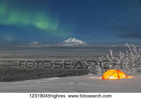 Green Aurora Borealis shines above moonlight casting light on Mount Drum and the Copper River Valley, a glowing tent on a foggy winter night, Copper River Valley, South-central Alaska; Alaska, United States of America View Large Photo Image Stock Photograph - Green Aurora Borealis shines above moonlight casting light on Mount Drum and the Copper River Valley, a glowing tent on a foggy winter night, Copper River Valley, South-central Alaska; Alaska, United States of America. Fotosearch