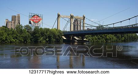 Stock Photograph - Hennepin Avenue Bridge crossing the Mississippi river and a sign for Grain Belt Beer; Minneapolis, Minnesota, United States of America. Fotosearch