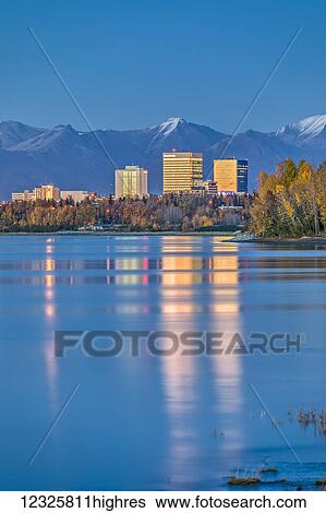 High tide on Cook Inlet shows the reflections of downtown Anchorage buildings just after sunset, the Chugach Mountains in the background, South-central Alaska; Anchorage, Alaska, United States of America View Large Photo Image Stock Photograph - High tide on Cook Inlet shows the reflections of downtown Anchorage buildings just after sunset, the Chugach Mountains in the background, South-central Alaska; Anchorage, Alaska, United States of America. Fotosearch