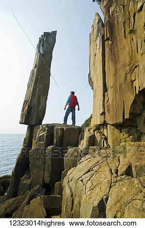 Hiker viewing the Balancing Rock and basalt rock cliffs, Bay of Fundy; Long Island, Nova Scotia, Canada View Large Photo Image Stock Photograph - Hiker viewing the Balancing Rock and basalt rock cliffs, Bay of Fundy; Long Island, Nova Scotia, Canada. Fotosearch