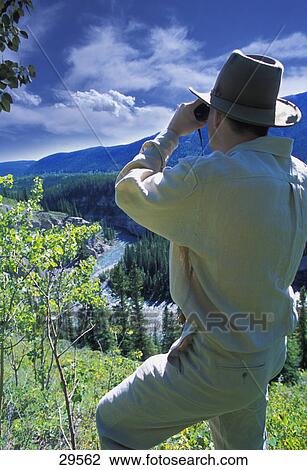 Stock Image - Hiker with binoculars enjoying view. Fotosearch