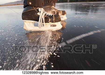 Hockey skates spraying ice on a frozen surface; Alaska, United States of America View Large Photo Image Stock Photograph - Hockey skates spraying ice on a frozen surface; Alaska, United States of America. Fotosearch