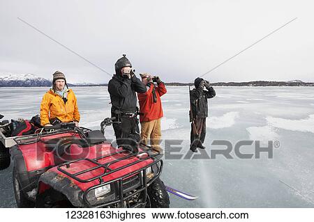 Stock Photograph - Hunters glassing while on a freshwater harbor seal hunt, Lake Iliamna, Pedro Bay, Southcentral Alaska, USA. Fotosearch