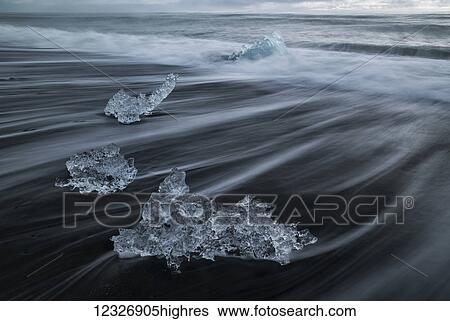 Stock Photograph - Ice chunks form the ice lagoon called Jokulsarlon along the South Coast of Iceland. This beach is called the Diamond Beach because of all the ice deposited here at high tide; Iceland. Fotosearch