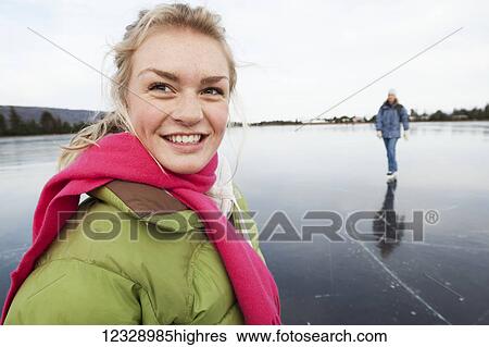 Stock Photograph - Ice skating on a frozen lake; Alaska, United States of America. Fotosearch