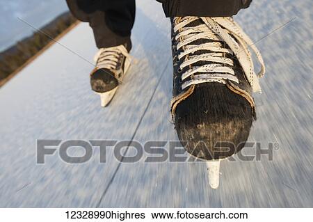 Ice skating with hockey skates on a frozen surface; Alaska, United States of America View Large Photo Image Stock Photograph - Ice skating with hockey skates on a frozen surface; Alaska, United States of America. Fotosearch