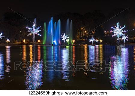 Illuminated snowflakes and a spraying water fountain illuminated with colourful lights reflected in water; Sunderland, Tyne and Wear, England View Large Photo Image Stock Photograph - Illuminated snowflakes and a spraying water fountain illuminated with colourful lights reflected in water; Sunderland, Tyne and Wear, England. Fotosearch