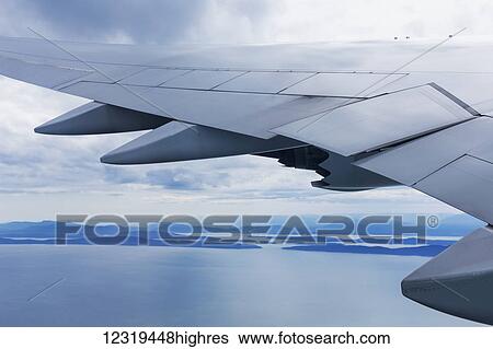 Stock Photograph - Korean Air Boeing 747 approaching Vancouver on a late afternoon in summer, over a calm ocean with islands and the coastline of British Columbia receding into the distance; Vancouver, British Columbia, Canada. Fotosearch