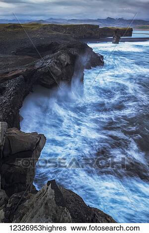 Large waves splash against the cliff sides of Dryholaey, Southern Iceland; Iceland View Large Photo Image Stock Photograph - Large waves splash against the cliff sides of Dryholaey, Southern Iceland; Iceland. Fotosearch