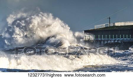 Stock Photograph - Large waves splashing along the shore; Sunderland, Tyne and Wear, England. Fotosearch