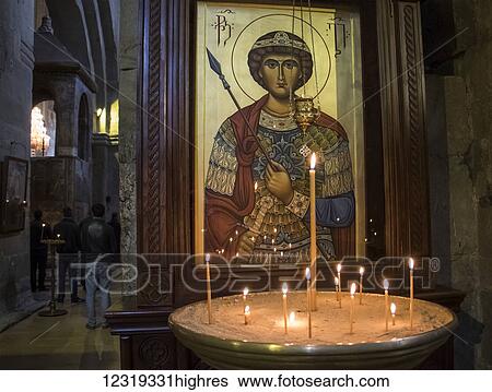 Stock Photograph - Lit candles by a Christian Orthodox icon in the interior of Svetitskhoveli Cathedral; Mtskheta, Mtskheta-Mtianeti, Georgia. Fotosearch