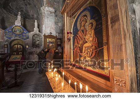 Stock Photograph - Lit candles by a Virgin and Child icon in the interior of Gergeti Trinity Church; Kazbegi, Mtskheta-Mtianeti, Georgia. Fotosearch